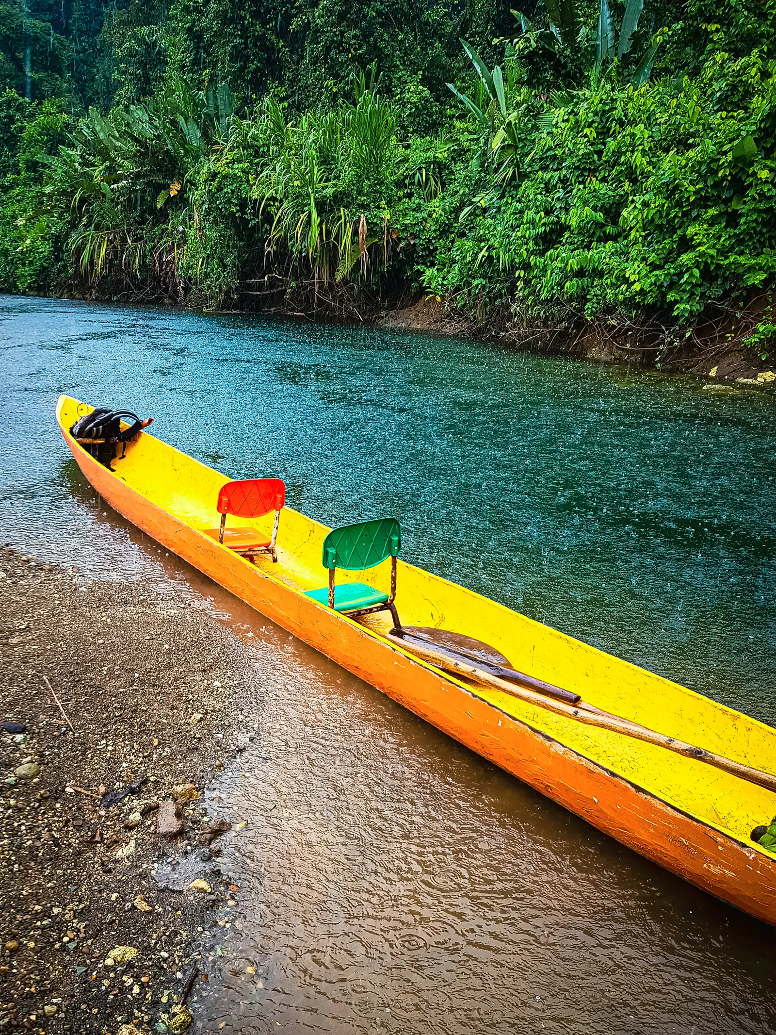 Canoa amarilla en la orilla de un río