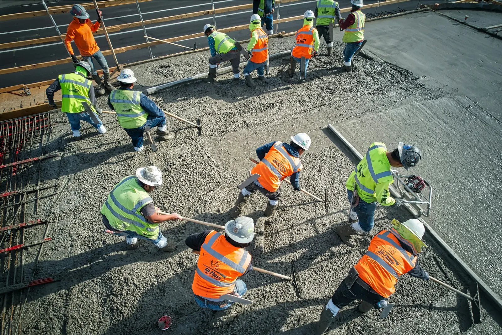 Trabajadores con casco vaciando concreto en una obra